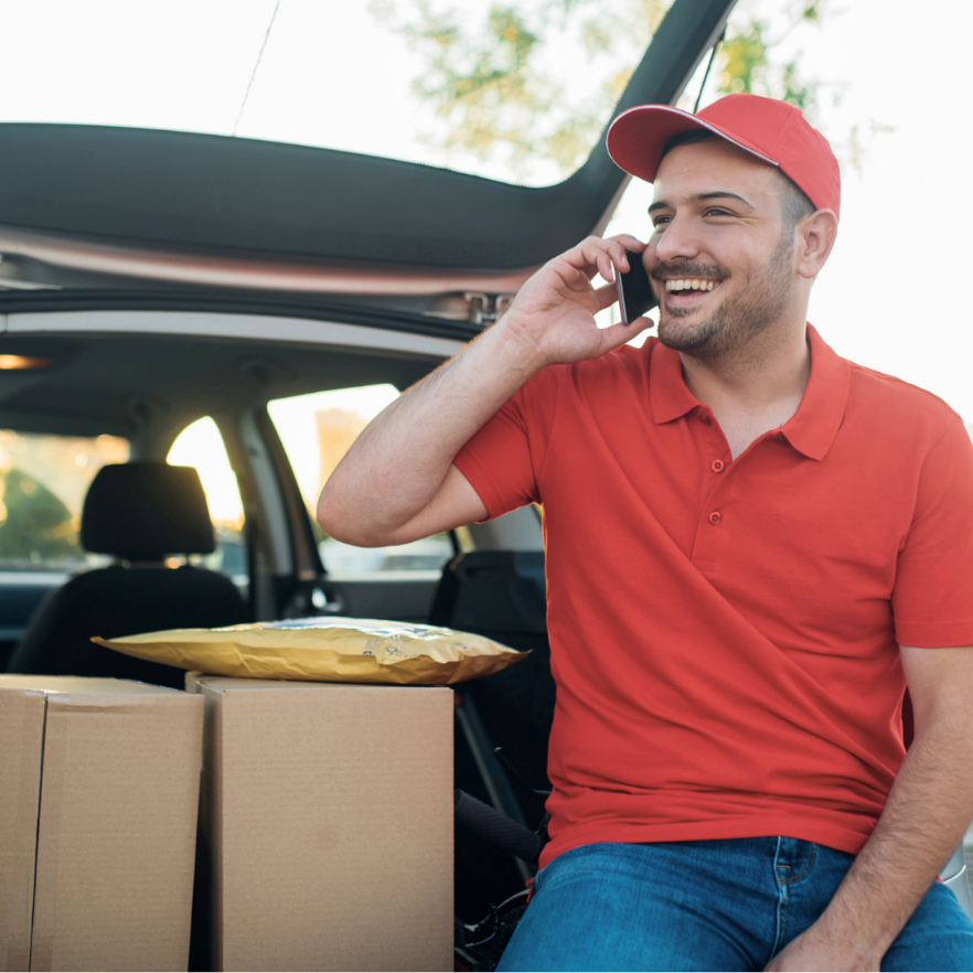 Happy delivery man talking to a customer on the phone Happy delivery man talking to a customer on the phone