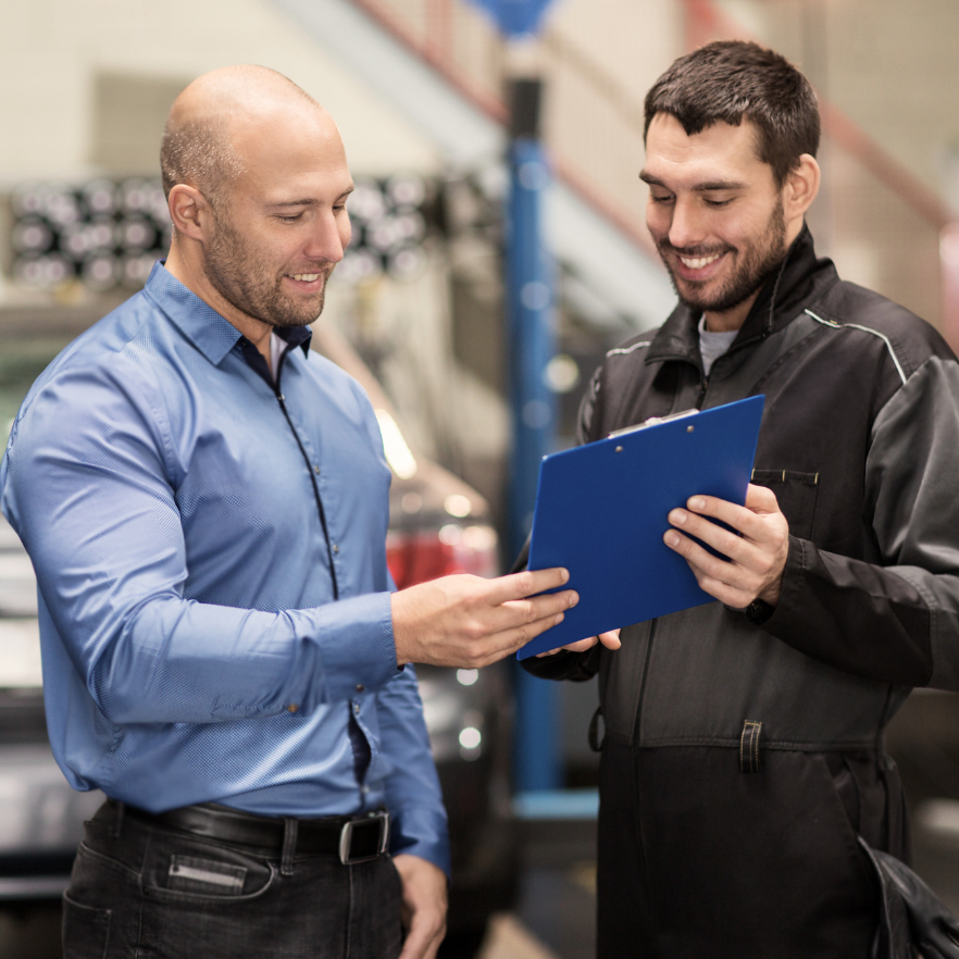 Mechanic speaking confidently with a male customer Mechanic speaking confidently with a male customer